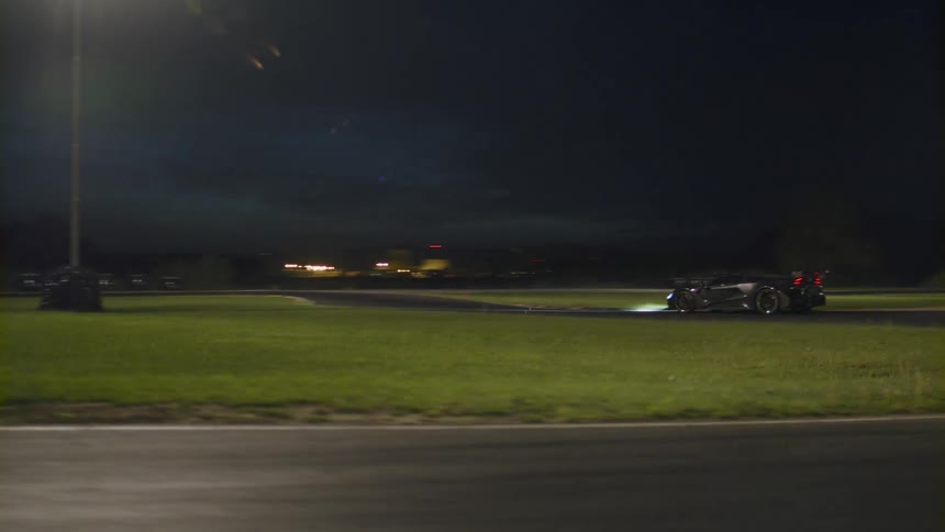 Sports car driving on a winding road at night