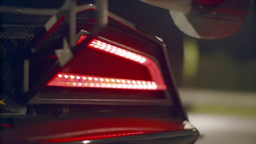 Light glows on red fixture on machine under light on pole