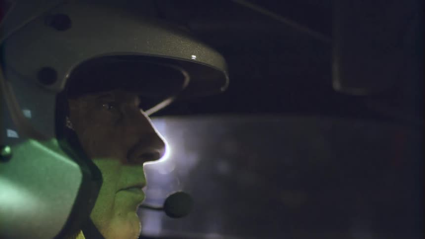 A person is driving a car while wearing a helmet