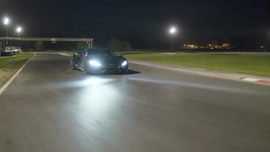 A car is driving outdoors at night