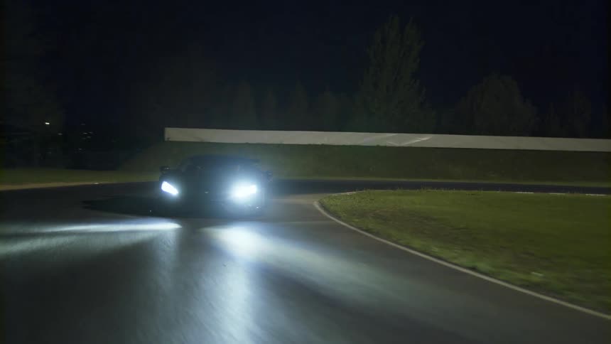 A car is driving on a road at night