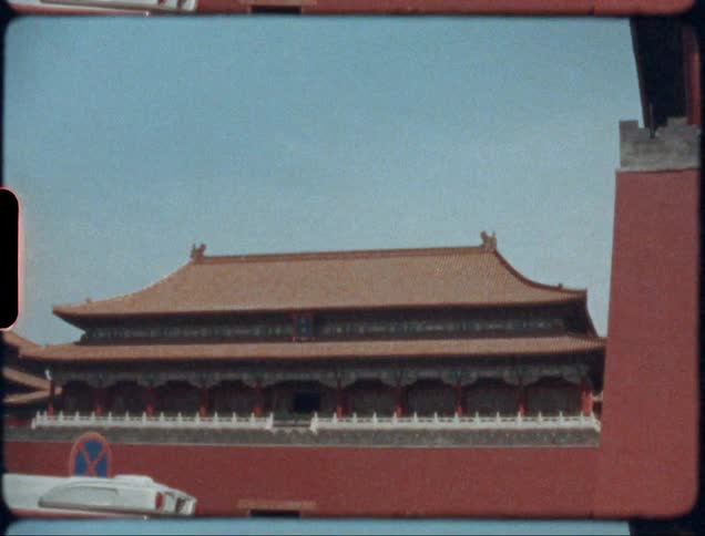 Film footage of a bus driving past a temple