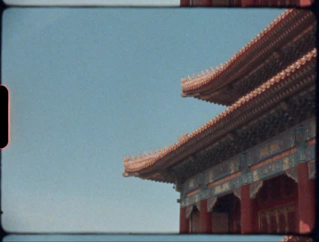 A building with pillars with the sky and clouds in the background