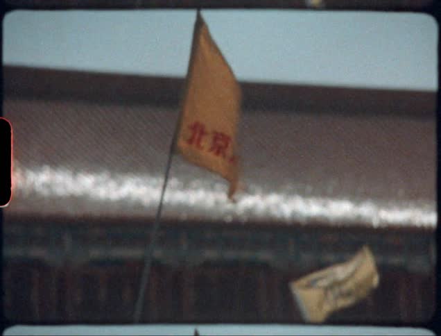 Banners flap on poles near building with snow dusted roof