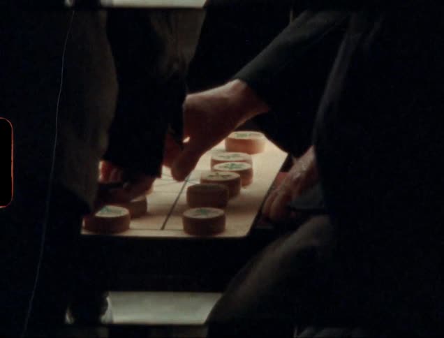 People play board game with large circular pieces