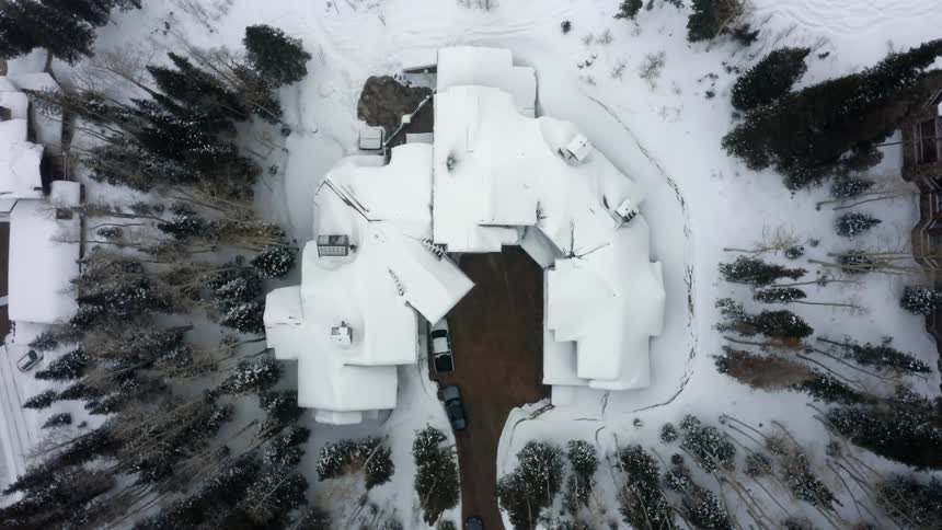 A large snow covered residence on a snowy day
