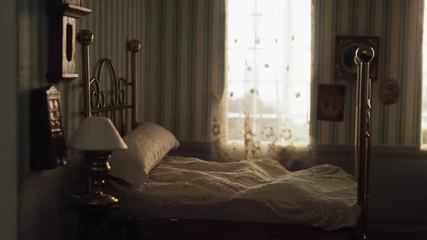 Miniature bed frame in a small dollhouse room