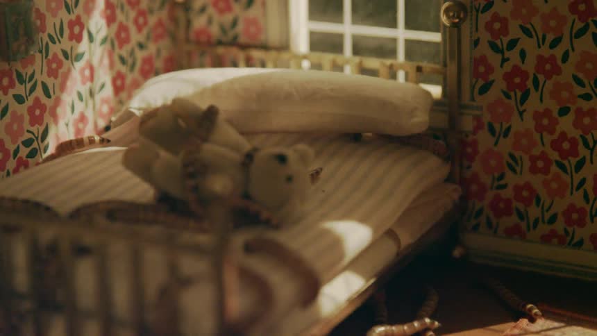 Worms crawling around on a stuffed animal inside of a miniature room