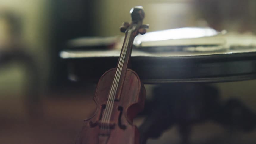 Miniature violin propped up next to a small table in a small room