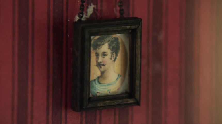 A painted portrait of a mustached man hands against red and black wallpaper