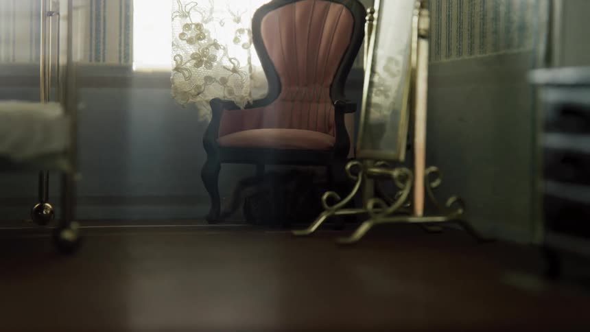 A miniature bedroom with a chair brass bed dressing mirror and dresser with a spider crawling in the corner of the room