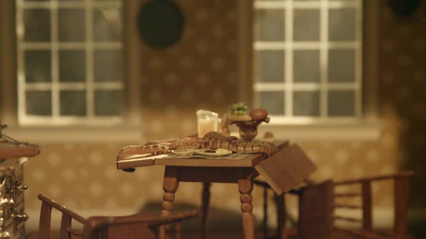 Close up of miniature dining room with chairs fallen over table windows and intermittent lights
