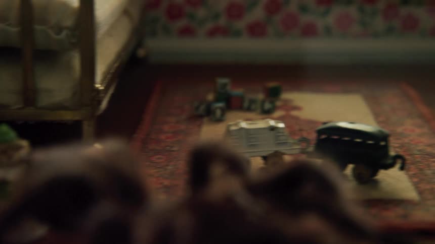 Large tarantula walking across a miniature room next to small toys