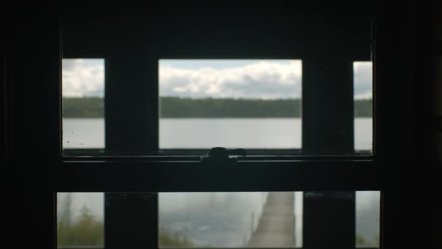Shot of body of water dock mountains taken inside house