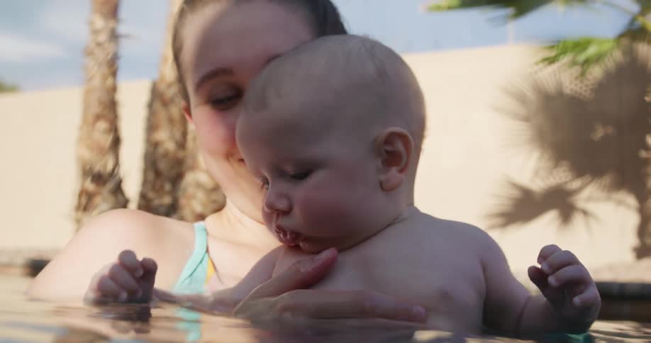 Mother and son swimming together in a swimming pool