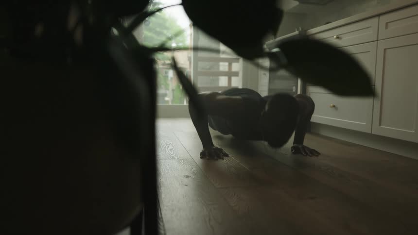 A man is working out in his kitchen