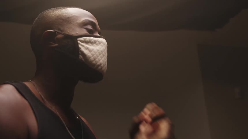 Man puts on a face mask and adjusts it to fit