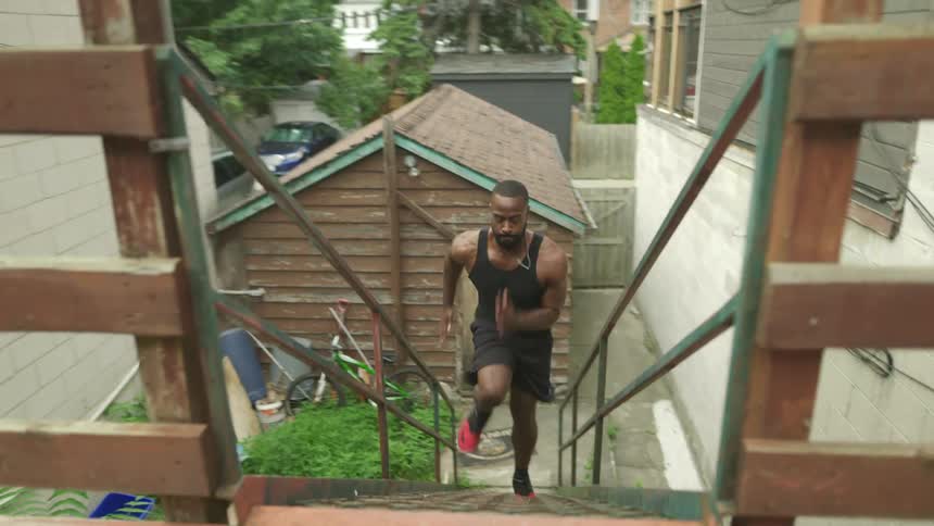 Man exercising running up a flight of stairs in a backyard
