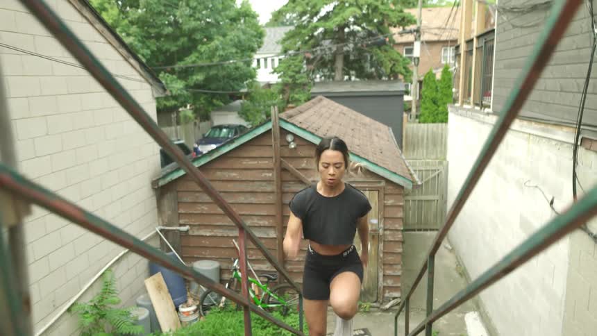 A woman is exercising on the stairs
