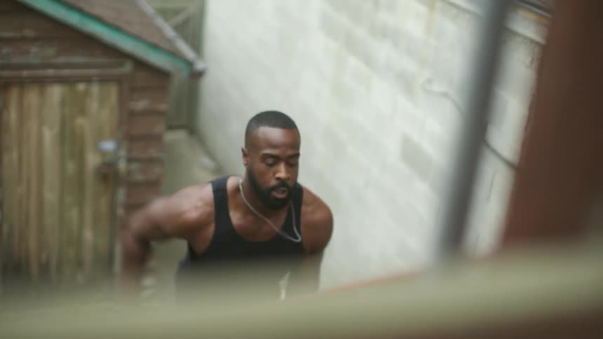 A man jogs up a set of stairs on the facade of a building during the day
