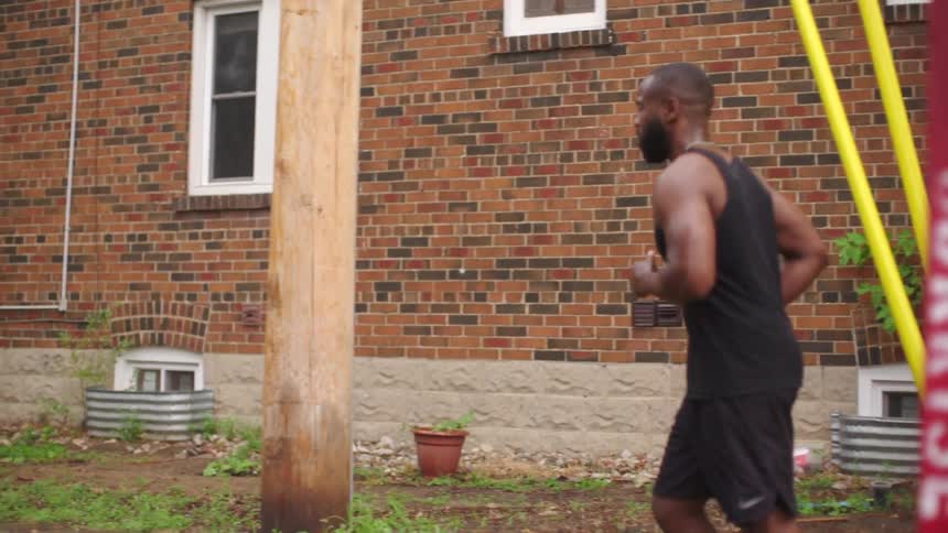 A young woman and a man jog through a residential neighborhood during the day