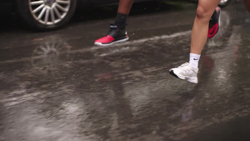 Feet running in the street on a rainy day