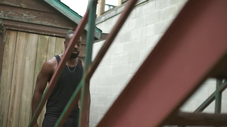 Man doing a high knee jump and running up a flight of stairs outside