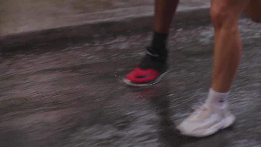 A young black couple running outside on a road