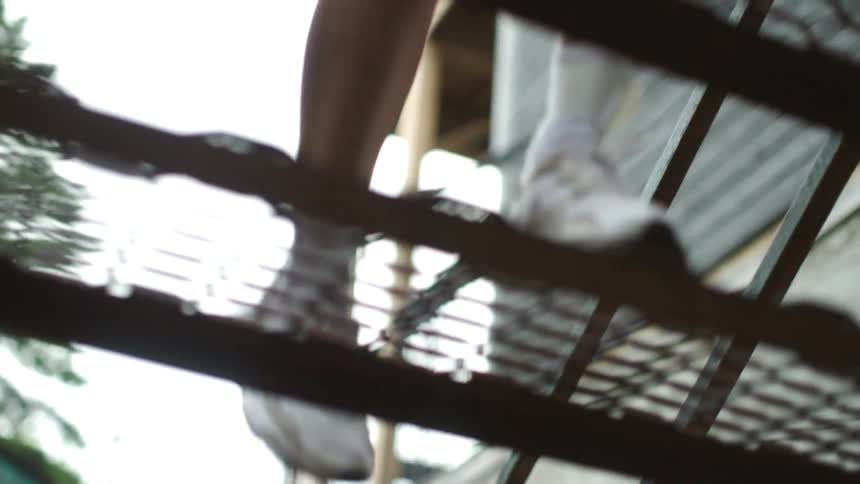 A woman runs up metal stairs outside exercising