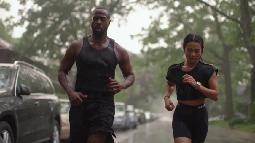 Man and woman jogging outside in the rain