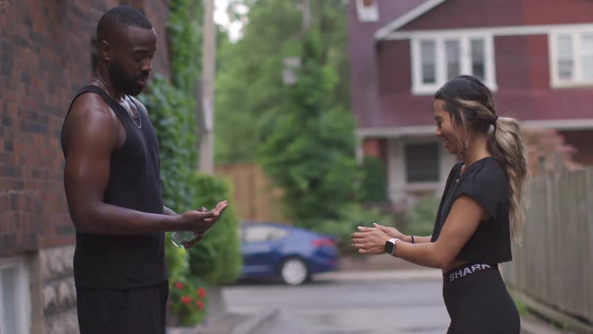 Man and a woman standing in an alleyway putting on hand sanitizer