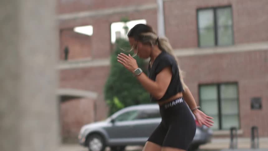 A young asian woman exercises outdoors in a city during the day