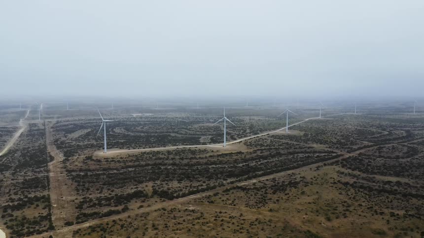 Wind turbines on wind farm in a grassland on a foggy day