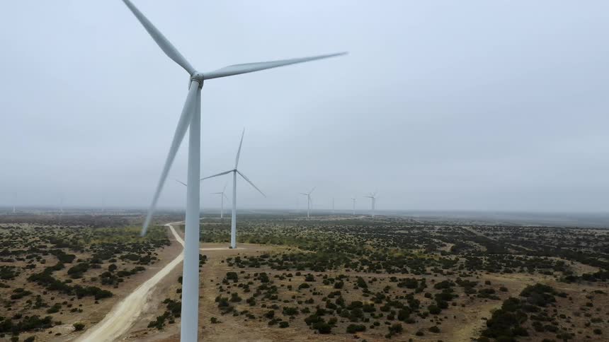 Wind turbines spinning in a field on a cloudy day