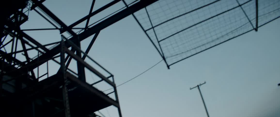 Large metal structure in a construction site next to a distant highway