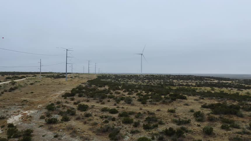 Wind turbines spin near a road