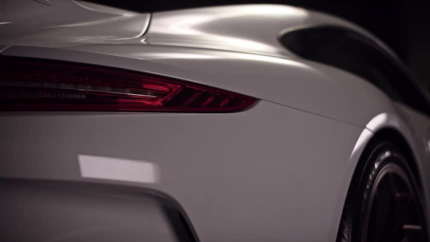 Shot of a white sportscar from the passenger door to the back brake light with shadows and light