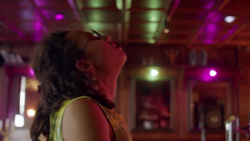 Woman inside of a building dancing sensually at a bar