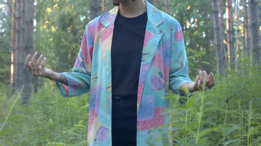 Woman standing outside in nature practicing a meditation stance