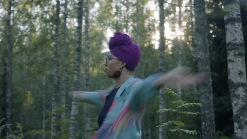Woman performing an interpretive dance out in the woods
