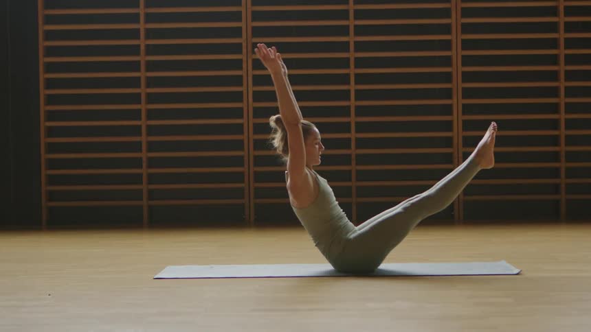 A woman lays on a mat before performing an impressive situp and exercises