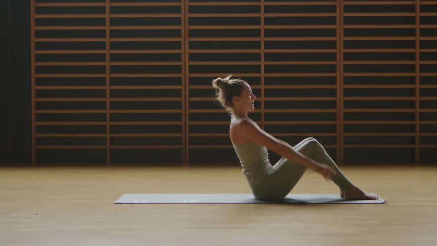 A woman is stretching on the floor in a room