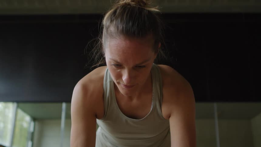 Woman doing push ups inside of a room with mirrors