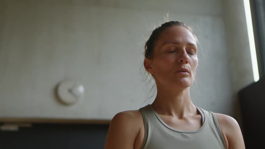 A woman is doing yoga in a room during the day