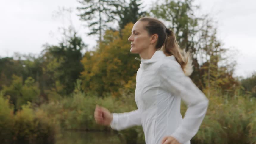 A woman is jogging outdoors in spring
