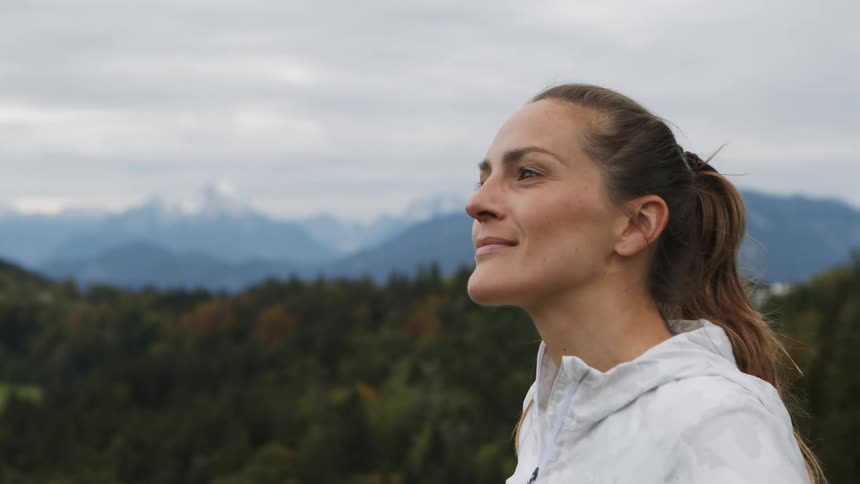 A woman looks at the landscape around her and smiles