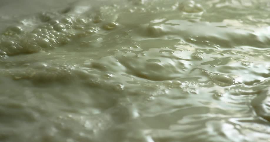 Flowing murky water moving around creating waves