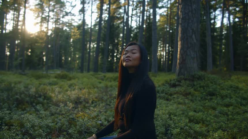 A woman is sitting in the forest during spring