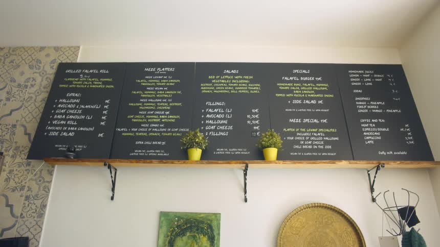 The large menu on a wall in a restaurant during the day
