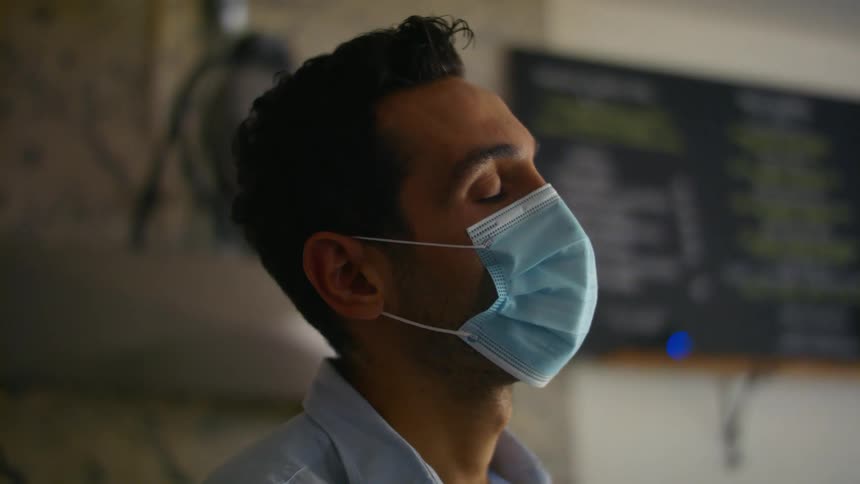 Man standing inside wearing a surgical face mask